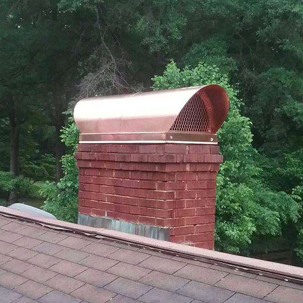 Original Custom Copper Traditional Hood-Owens Chimney Covers Custom Copper Traditional Hood on brick chimney with trees in background
