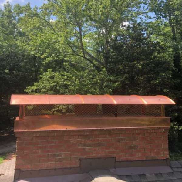 Custom outside mount chimney cap with barrel lid with trees in background